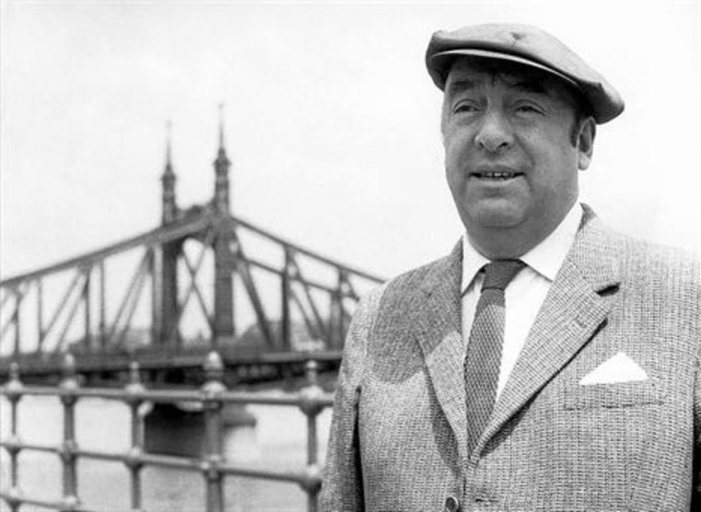 Hombre de mediana edad con gorra y traje claro posando frente al puente de Brooklyn, Nueva York
