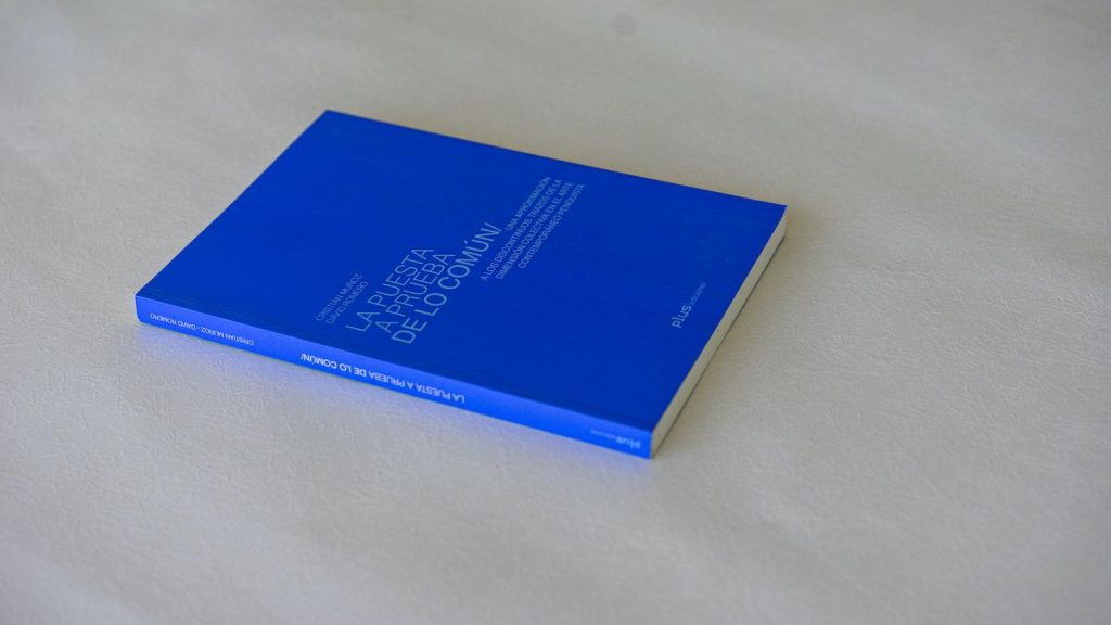 Libro de tapa azul con texto grabado, sobre superficie blanca