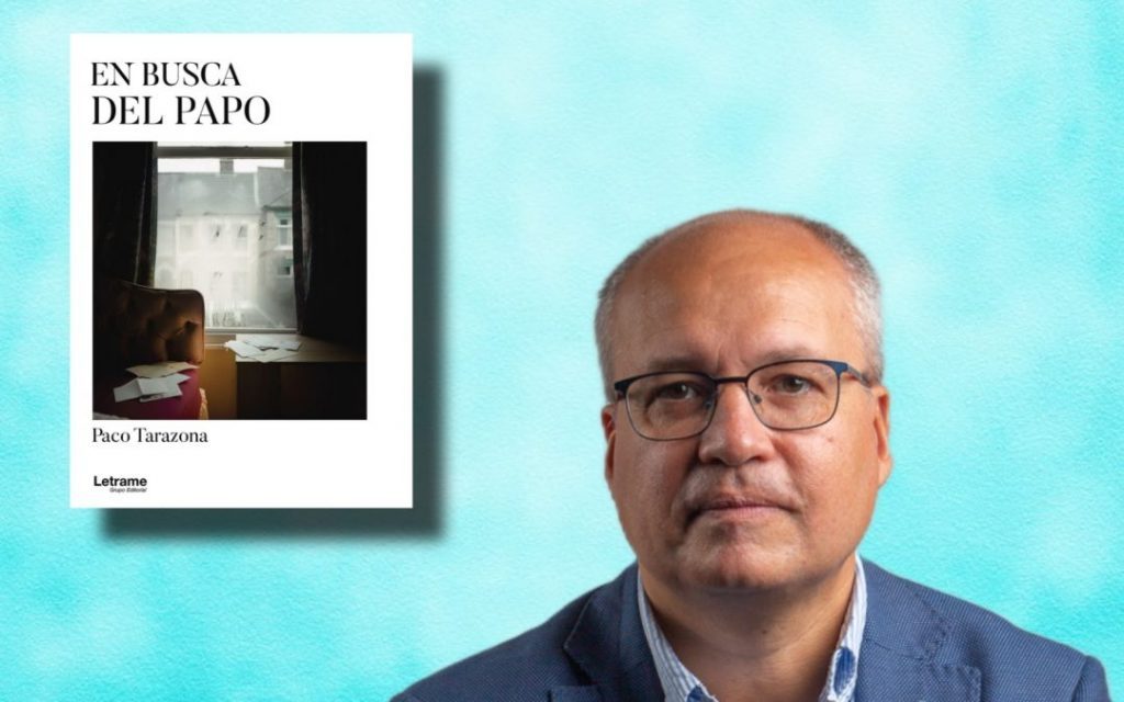 Paco Tarazona, escritor, junto a portada de su libro En busca del Papa sobre fondo azul