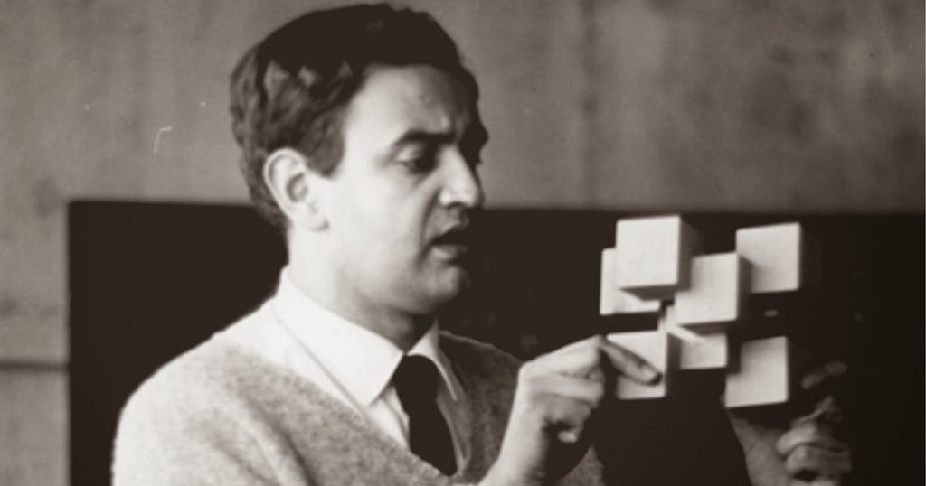 Tomás Maldonado observa atentamente notas adhesivas en una pared, durante una sesión de trabajo de diseño