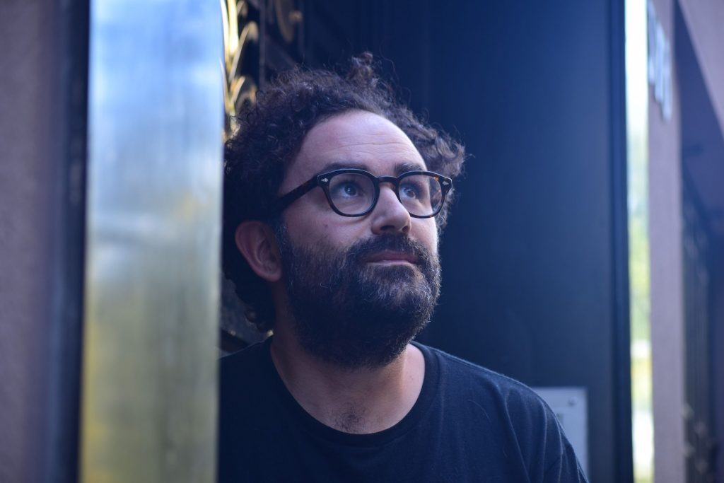 Gonzalo Maier, hombre con barba y anteojos, mira hacia un lado en ambiente de iluminación azul