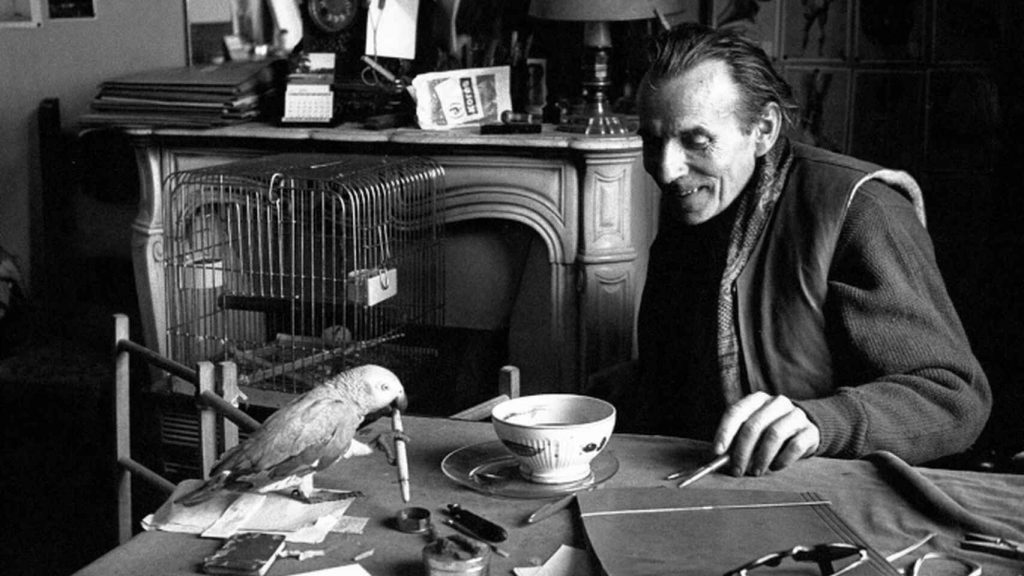 Louis-Ferdinand Céline en su escritorio, rodeado de papeles y libros, en fotografía blanca y negra