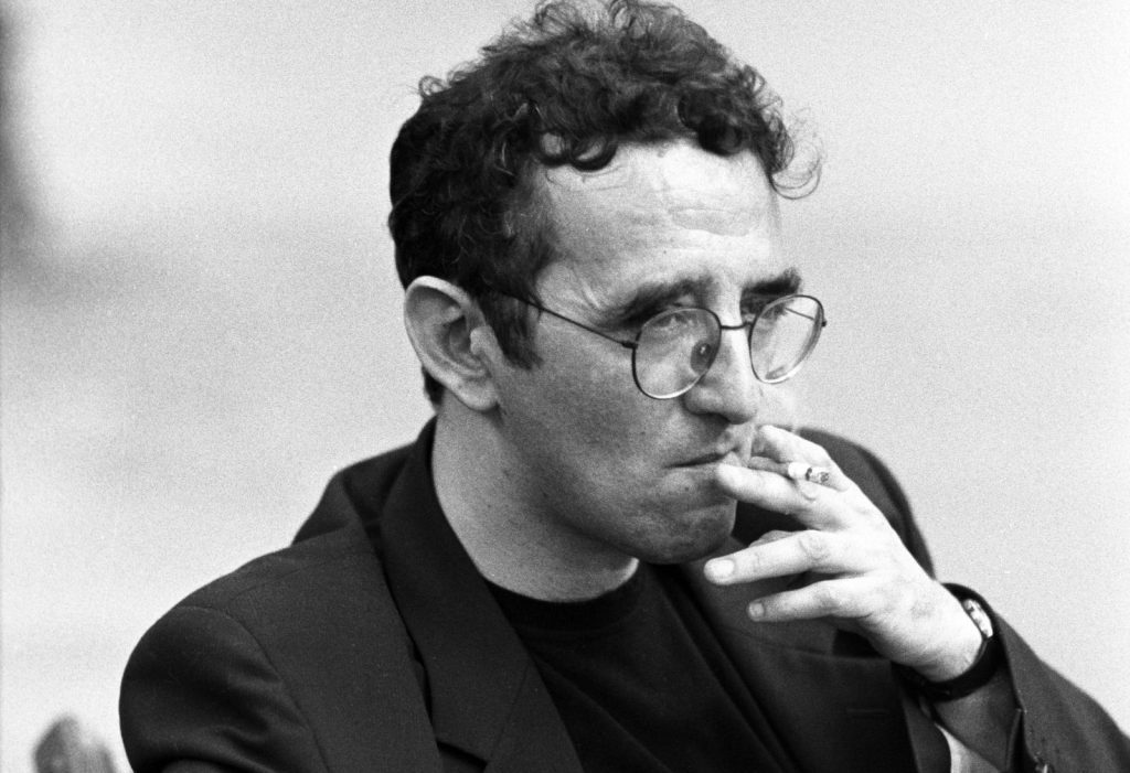 Roberto Bolaño, escritor chileno, retrato en blanco y negro fumando cigarrillo, gafas, expresión pensativa