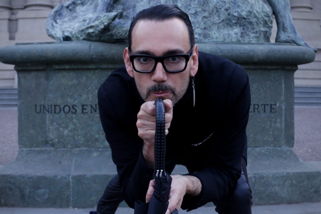 Juan Pablo Sutherland hablando al micrófono frente a edificio de Bellas Artes