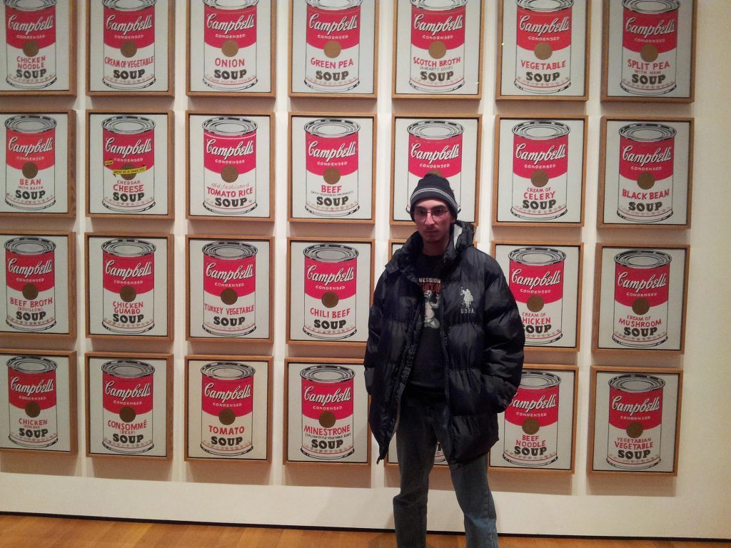 Maximiliano Yáñez Gutiérrez ante la instalación de arte pop con latas de sopa Campbell, en galería de museo