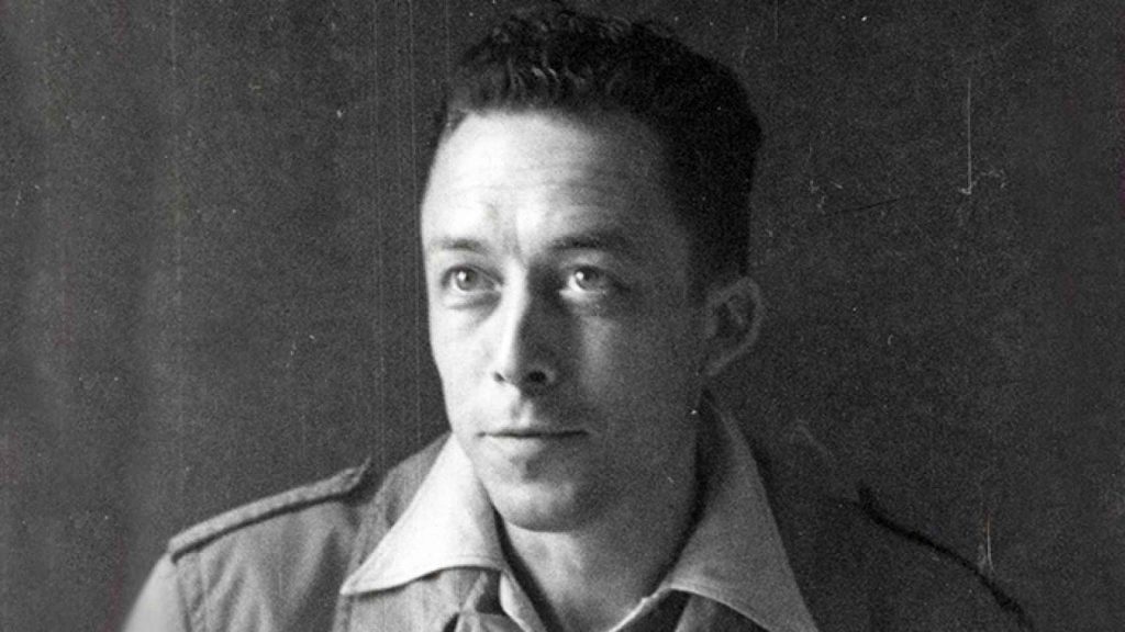 Albert Camus, escritor francés, retrato en blanco y negro con uniforme militar de cuello claro, mirada frontal
