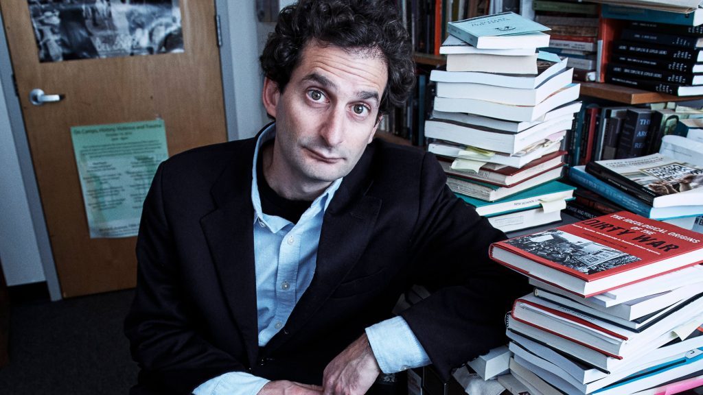 Federico Finchelstein, historiador, sentado ante escritorio rodeado de libros y documentos en su oficina
