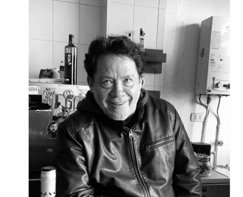 Gonzalo Contreras Loyola en una cocina, sonriendo hacia la cámara, vistiendo una chaqueta de cuero negra