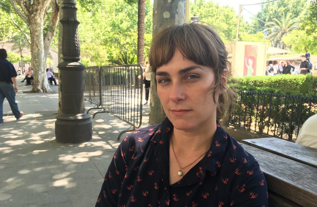Sara Mesa, escritora española, en un parque urbano con árboles de fondo, retrato en primer plano