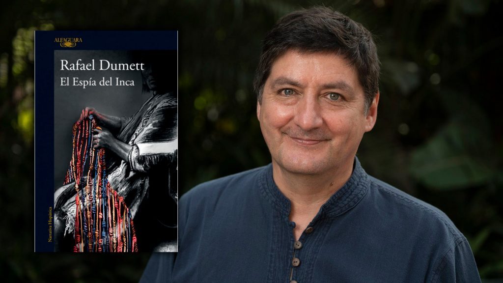 Rafael Dumett junto a la portada de su novela El espía del Inca, con diseño en tonos rojos y negros