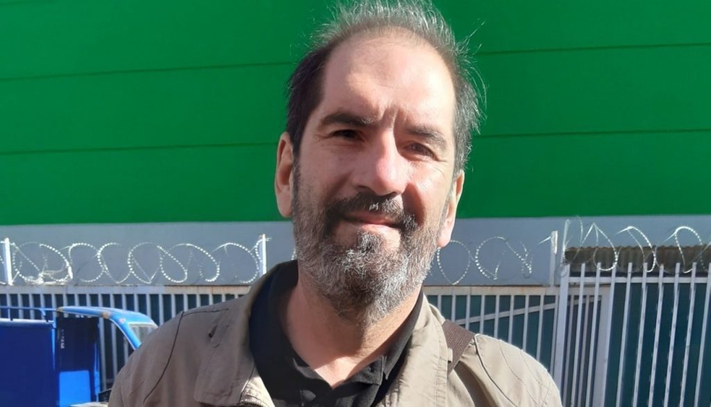Esteban Salinero, hombre con barba, frente a fondo verde y valla metálica azul