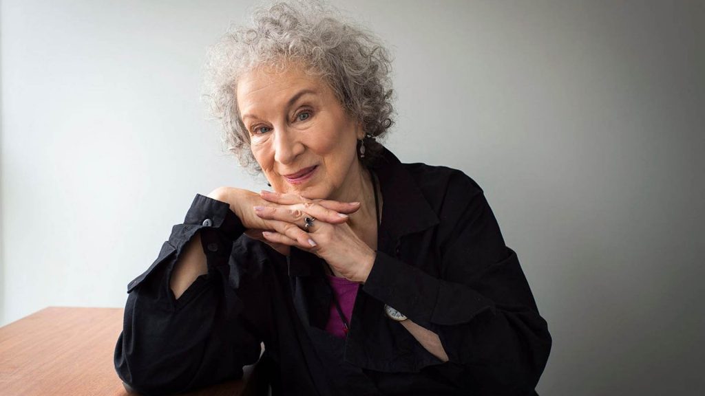 Margaret Atwood, autora canadiense con cabello gris, sonriendo hacia la cámara en retrato profesional