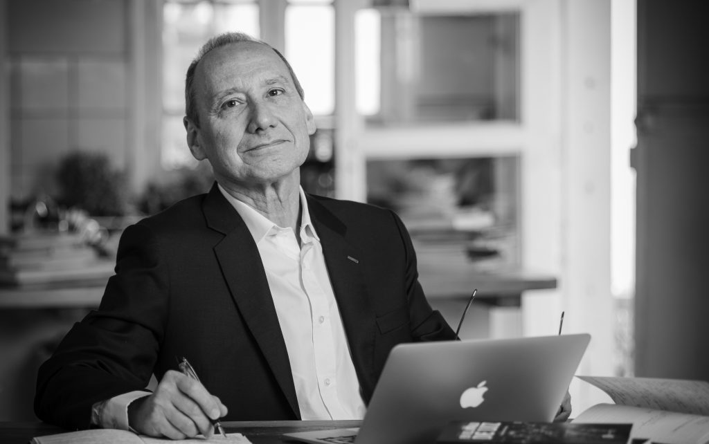 Claudio Suárez Cruzat trabajando en laptop, fotografía en blanco y negro, ambiente de oficina