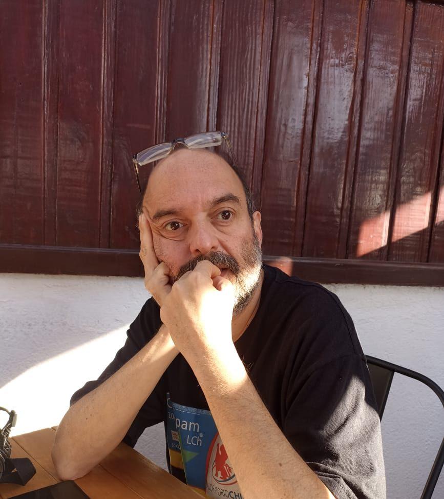 Camilo Brodsky, poeta chileno, en retrato de medio cuerpo con gafas sobre la cabeza y expresión reflexiva