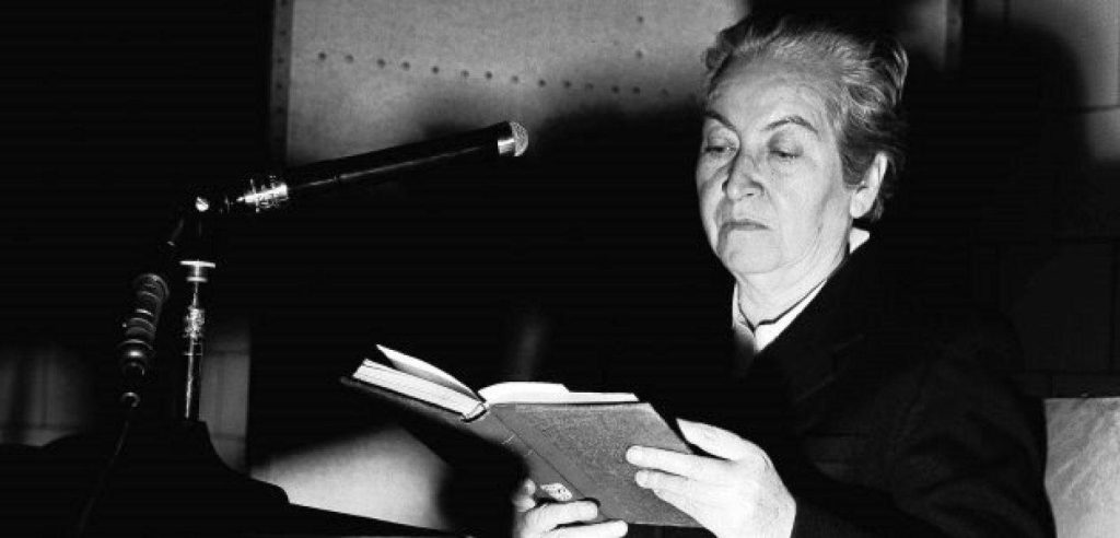 Gabriela Mistral, poeta chilena, lee un libro bajo luz de estudio en fotografía en blanco y negro