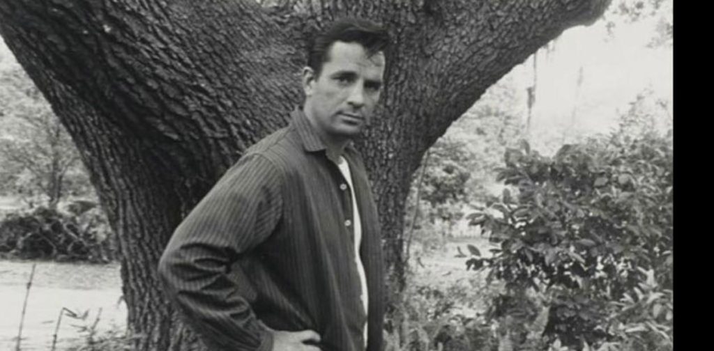 Jack Kerouac apoyado en un árbol, fotografía en blanco y negro, mirada contemplativa hacia la cámara