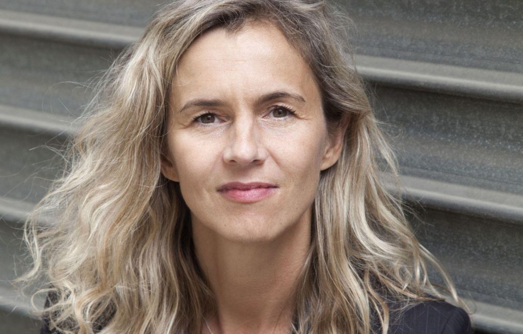 Delphine de Vigan, escritora francesa, retrato en primer plano con fondo de escaleras grises