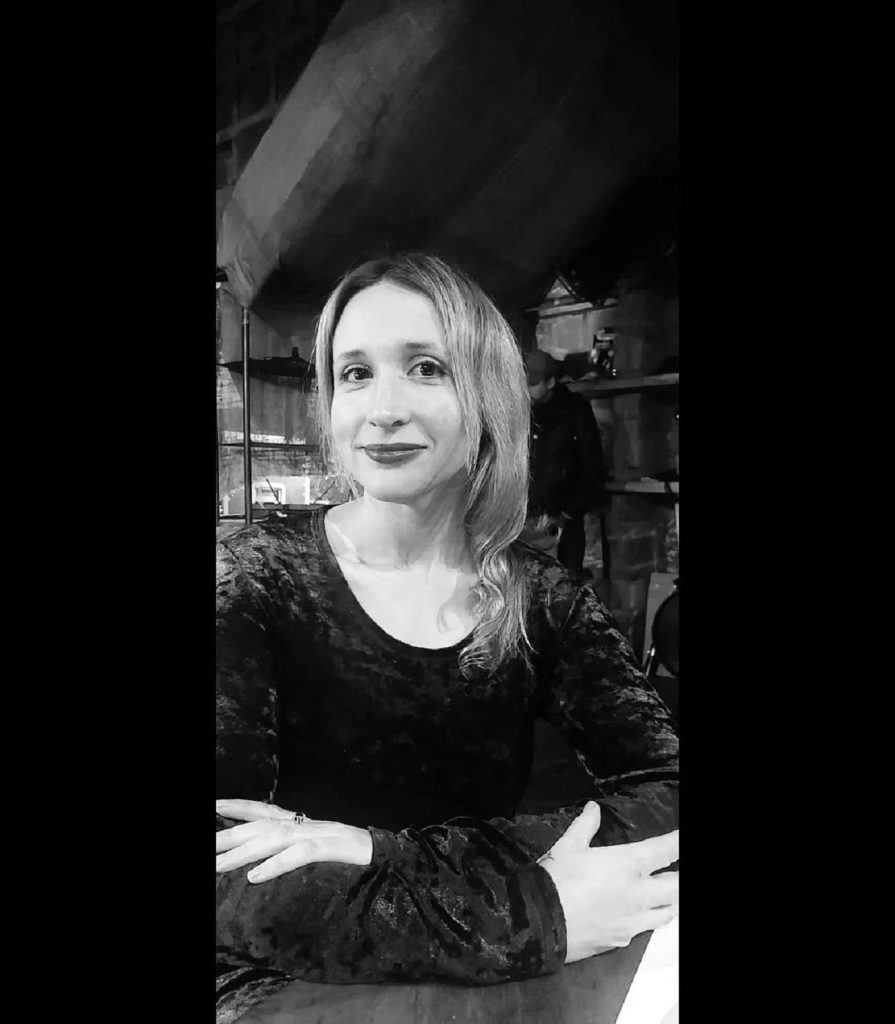Gabriela Paz, poeta, retratada en blanco y negro con expresión reflexiva, vistiendo blusa oscura