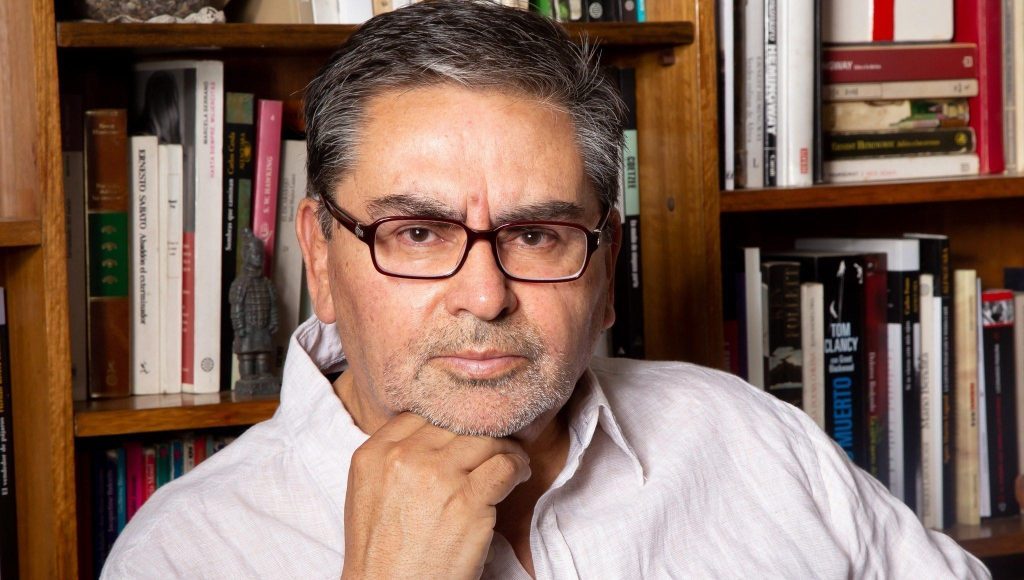 Diego Cancino, hombre de mediana edad con gafas, junto a estantería con libros de fondo