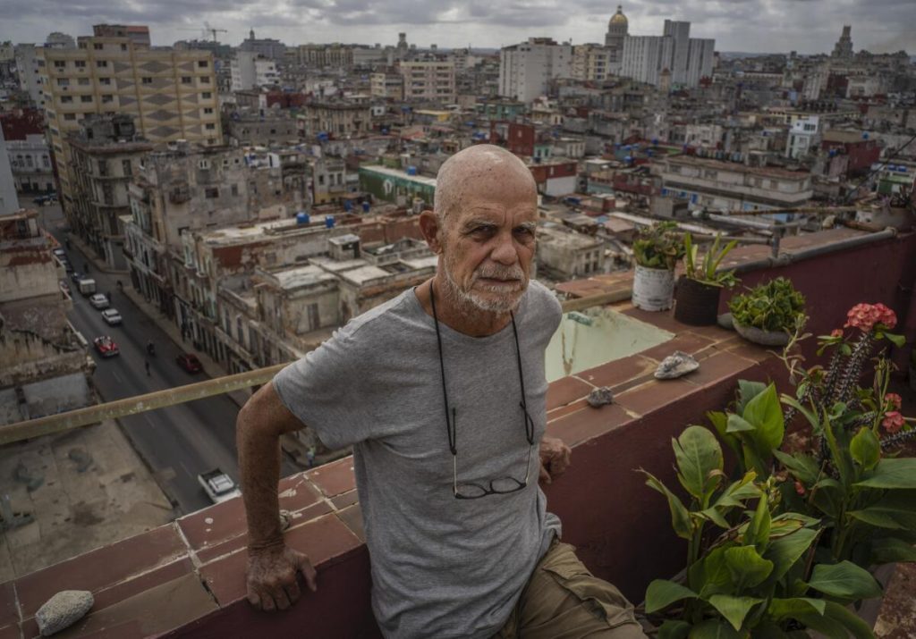 Escritor Pedro Juan Gutiérrez en azotea de edificio habanero con vistas a la ciudad de La Habana al fondo