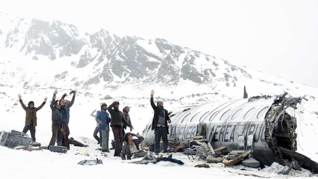 Supervivientes en la nieve junto a restos de avión estrellado en montaña nevada y desolada