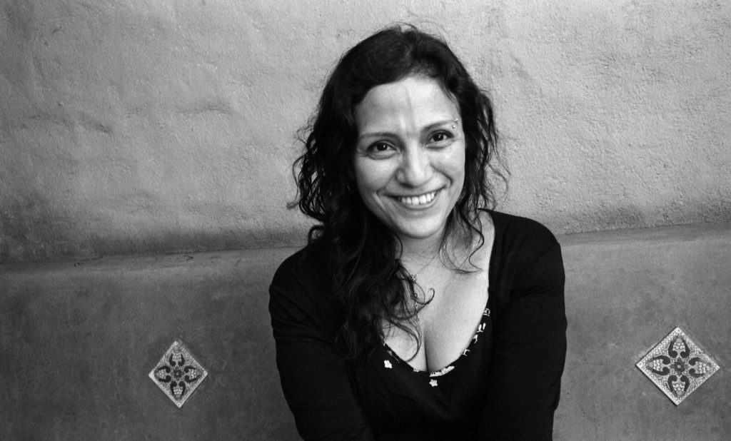 Claudia Ulloa Donoso, escritora, en fotografía en blanco y negro con fondo neutro