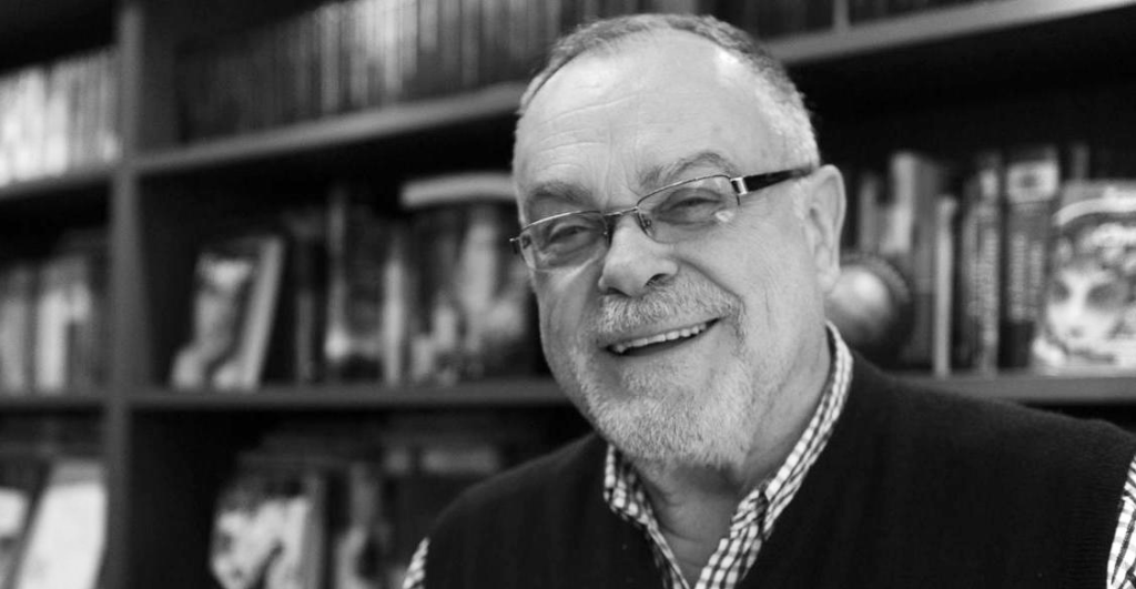 Mempo Giardinelli, escritor argentino, sonríe ante estantería de libros de fondo