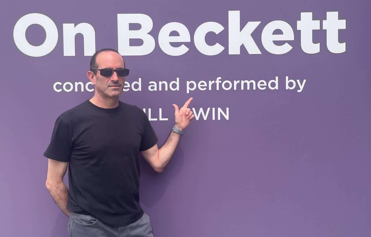 Nicolás Poblete Pardo gesticula mientras habla frente a fondo púrpura con texto On Beckett