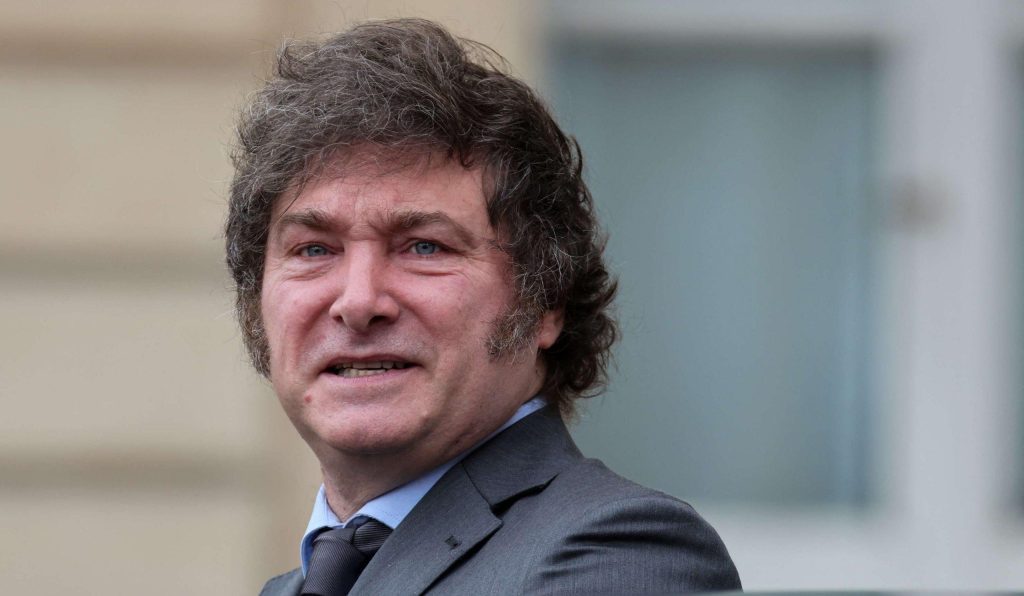 Javier Milei, político argentino, sonríe de frente vistiendo traje azul marino y corbata