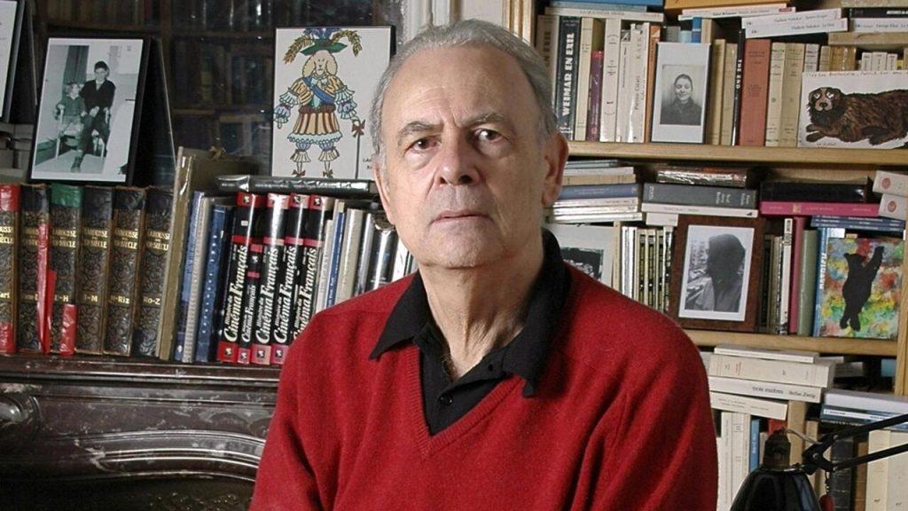 Patrick Modiano, escritor francés, frente a estantería con libros y fotografías en blanco y negro