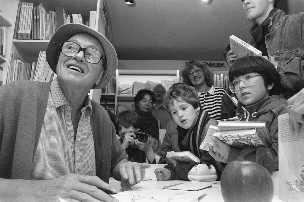 Roald Dahl firma libros ante niños en librería de Amsterdam, rodeado de pequeños lectores atentos