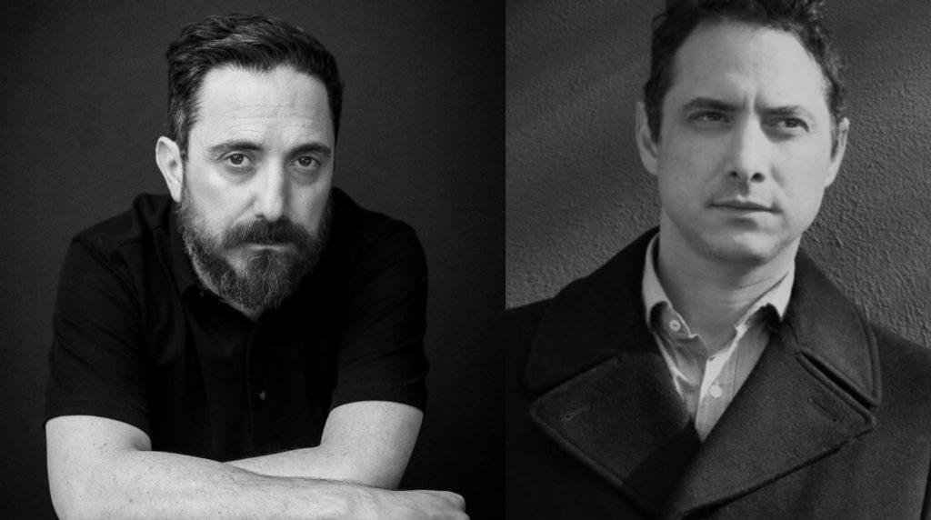 Retrato en blanco y negro de dos hombres: escritor con barba en polo negro a la izquierda y hombre de cabello oscuro