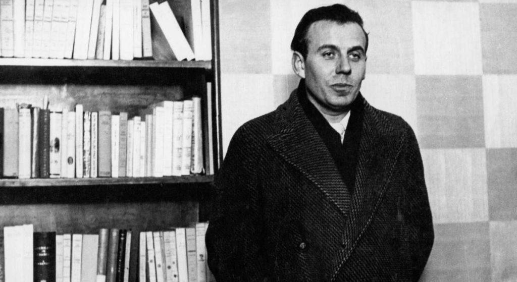Louis-Ferdinand Céline frente a estantería de libros, retrato en blanco y negro, años cincuenta