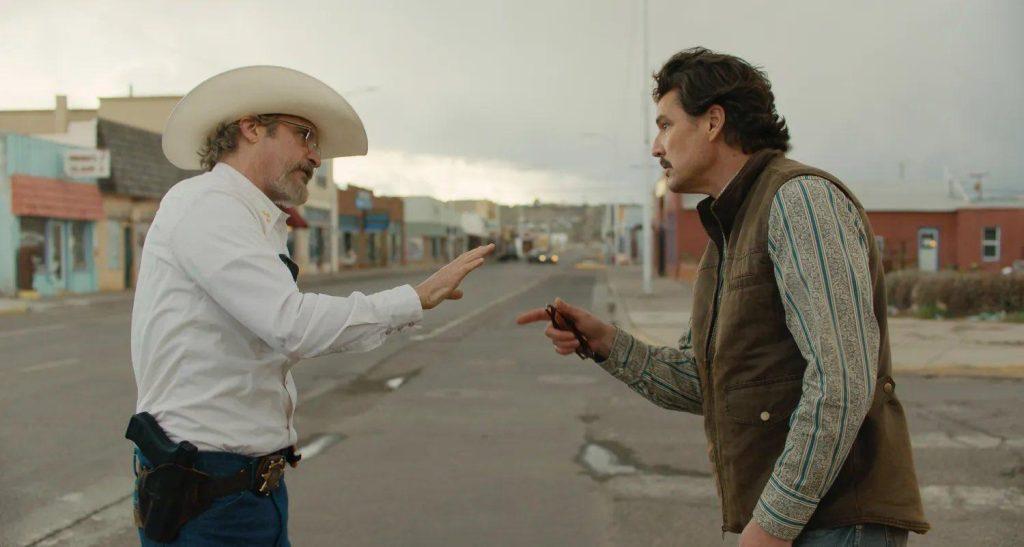 Dos hombres en confrontación en una calle desértica de un pueblo oeste, uno con sombrero vaquero blanco y otro