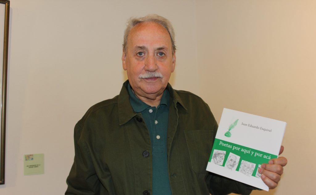 Juan Eduardo Esquivel sostiene un libro verde mientras posa para la fotografía en interior