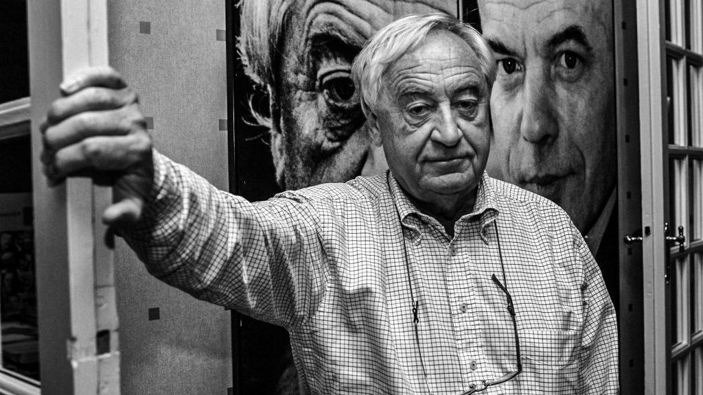 Cees Nooteboom, escritor holandés, señala hacia una fotografía en blanco y negro durante una entrevista o evento