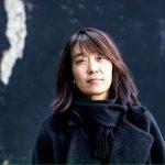 Han Kang, autora surcoreana, retratada en primer plano con expresión pensativa frente a fondo oscuro