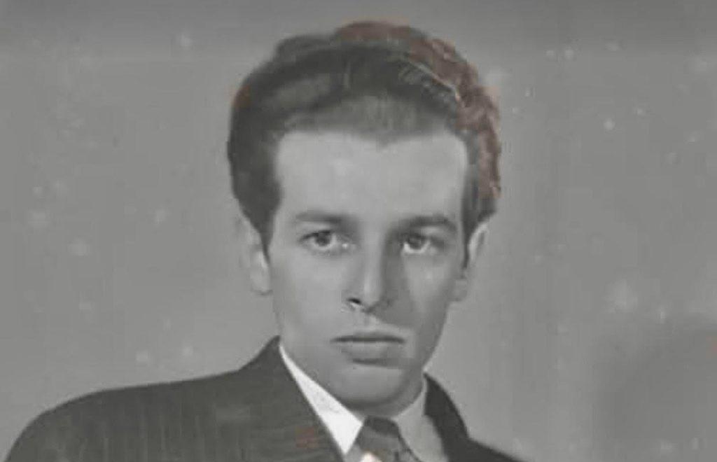 Retrato en blanco y negro de Alejandro Jodorowsky de joven, vestido con traje y corbata